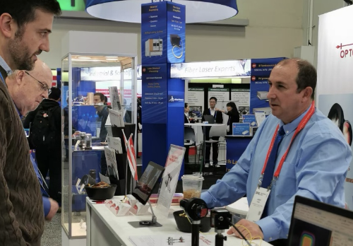 Customer consultation at optics trade show for precision optical requirements